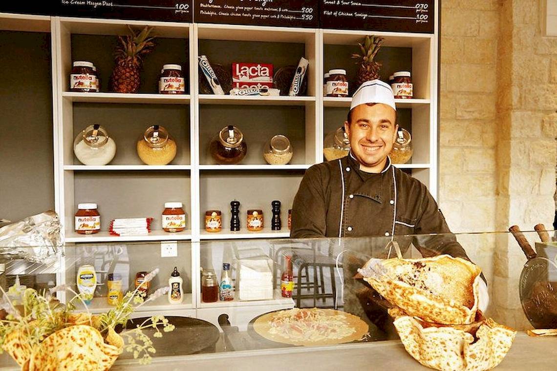 Ein Mann im Ostria Resort & Spa Hotelrestaurant mit Lebensmitteln vor Schülchen.