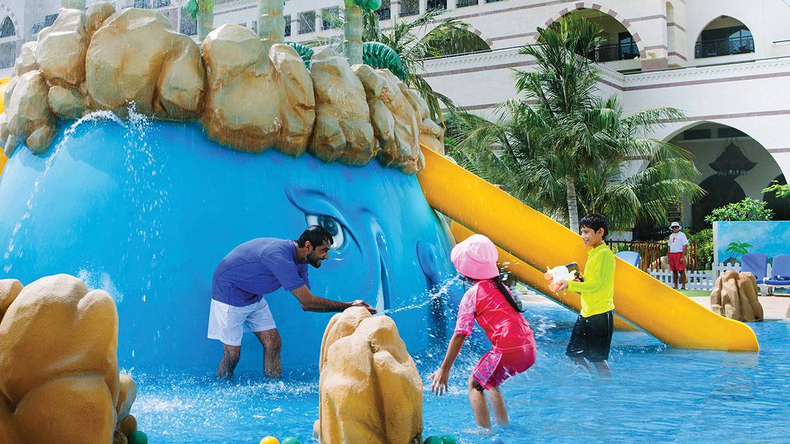 Familie im Schwimmbad des Jumeirah Zabeel Saray mit Wasserrutsche und Wasserfontäne