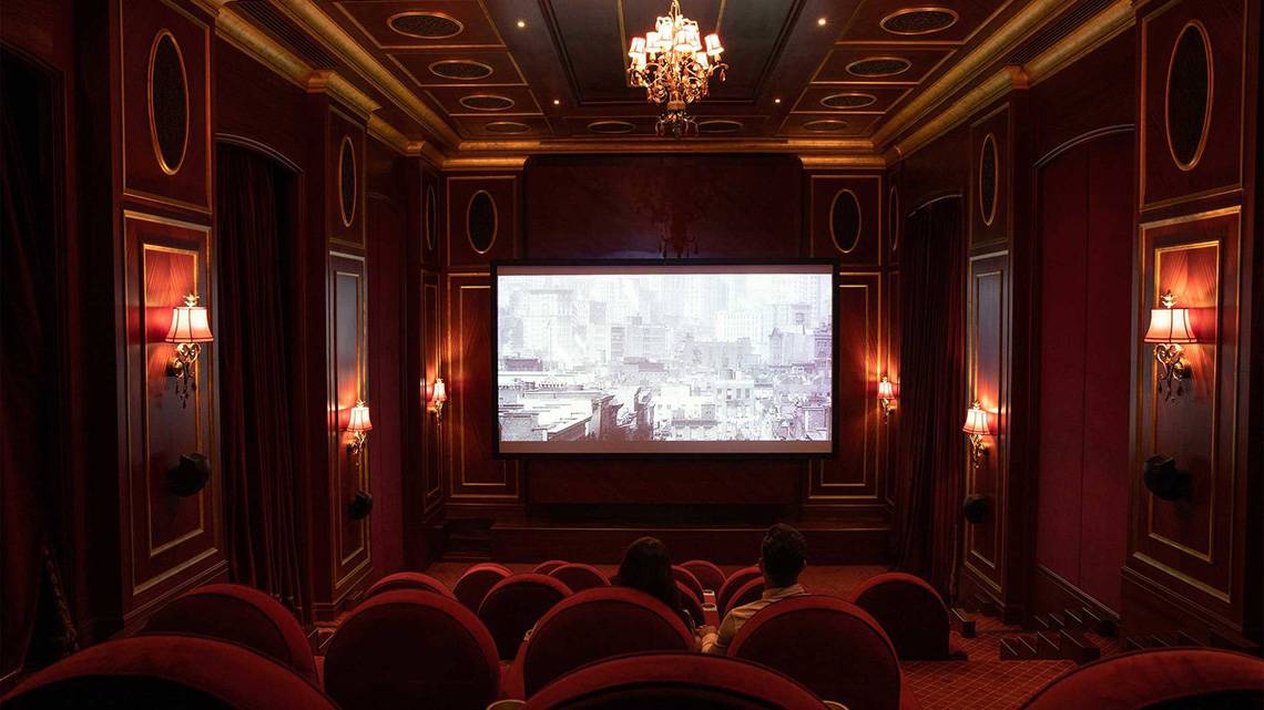 Innenraum des Kinosaals im Jumeirah Zabeel Saray Hotel mit roten Stühlen und einer großen Leinwand.