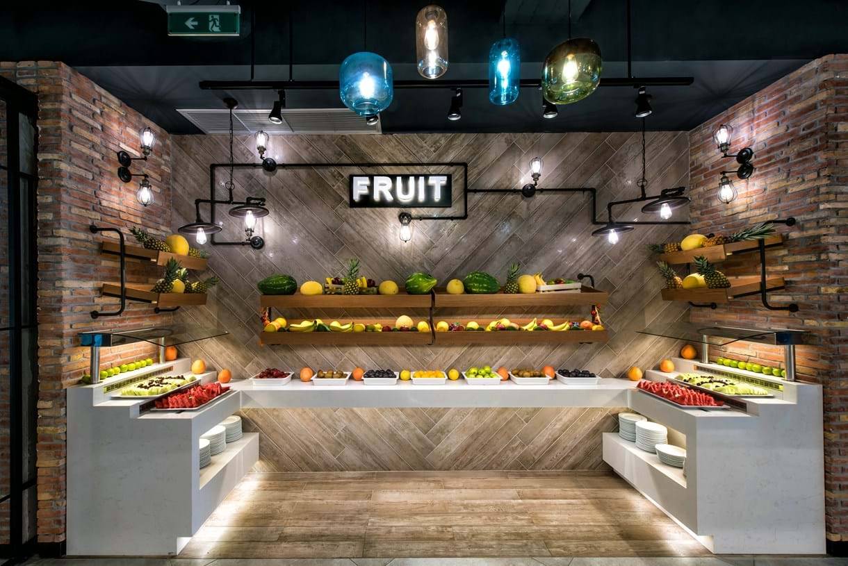 Obstbuffet im Fodele Beach & Water Park Holiday Resort mit verschiedenen Früchten und Lampen.