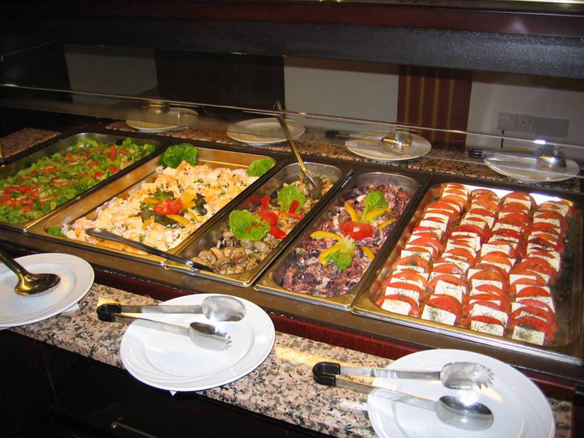Buffet mit verschiedenen Salaten und Sandwiches in einer Hotelhalle.