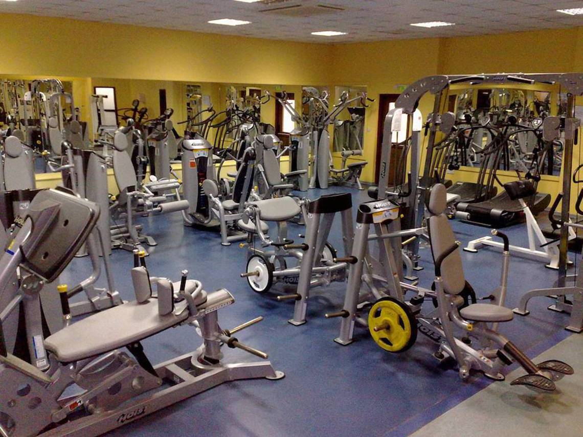 Fitnessstudio im Aktea Beach Village Hotel mit vielen Trainingsgeräten und gelben Wänden