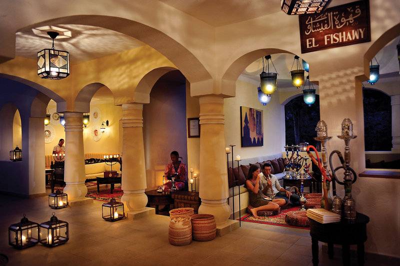 Loungbereich im Bahari Zanzibar Hotel mit runden Hütten und hängenden Laternen.