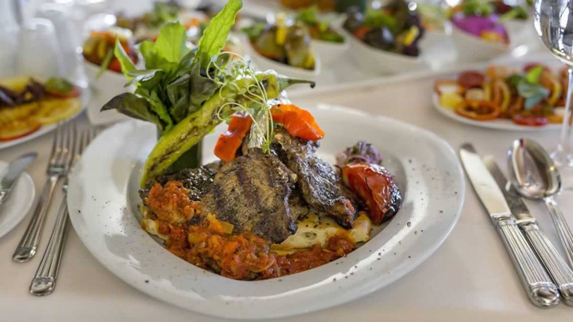 Speiseplatte im Royal Wings Hotel mit gegrilltem Fleisch, Tomaten und Salat.