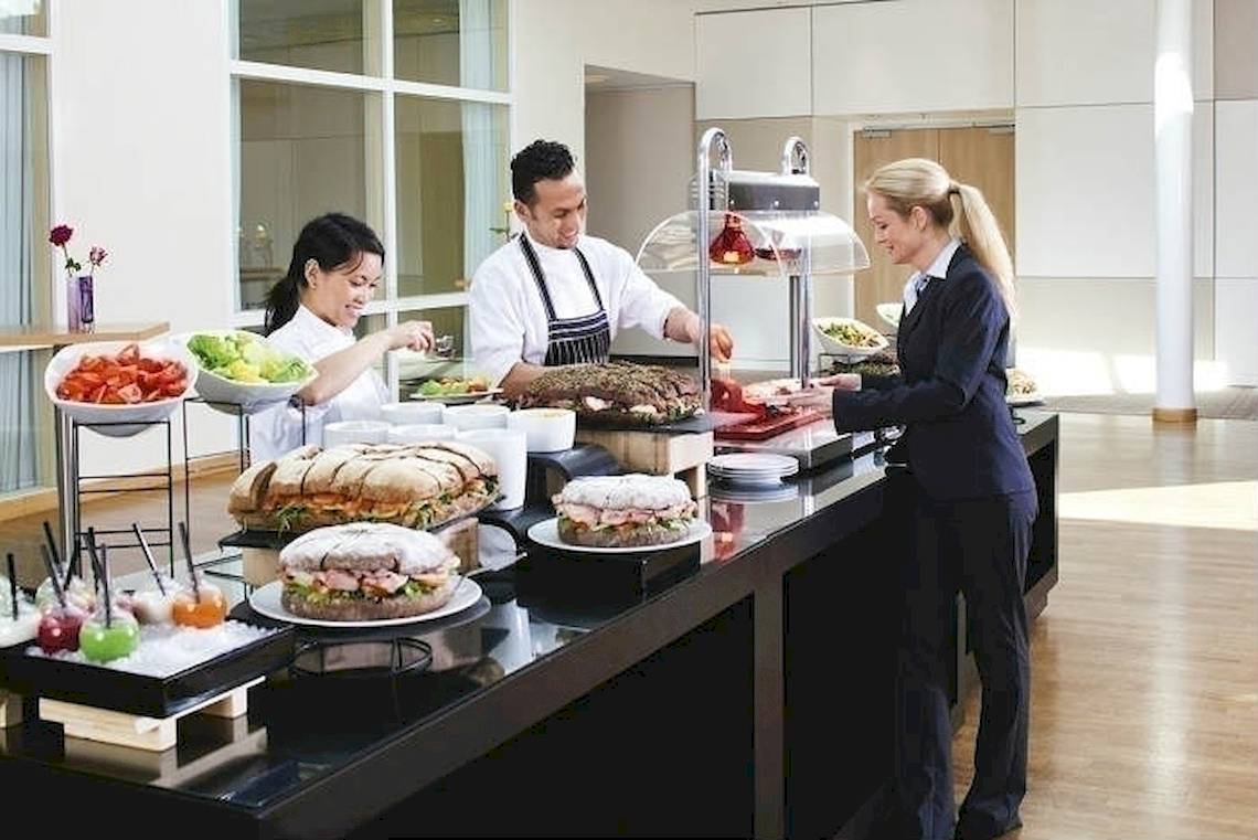 Buffet im Mövenpick Amsterdam City Centre mit verschiedenen Speisen und Angestellten
