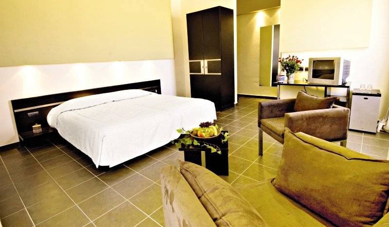 Innenansicht eines Hotelzimmers im Royal Decameron Tafoukt Beach Hotel mit Bett, Fernseher und Möbeln.