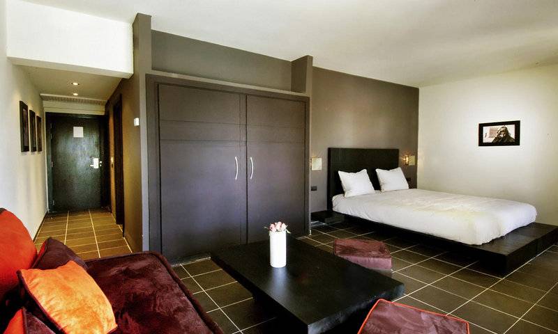 Zimmer im Royal Decameron Tafoukt Beach Hotel mit Bett, Sofa, Tisch und Dekoration.