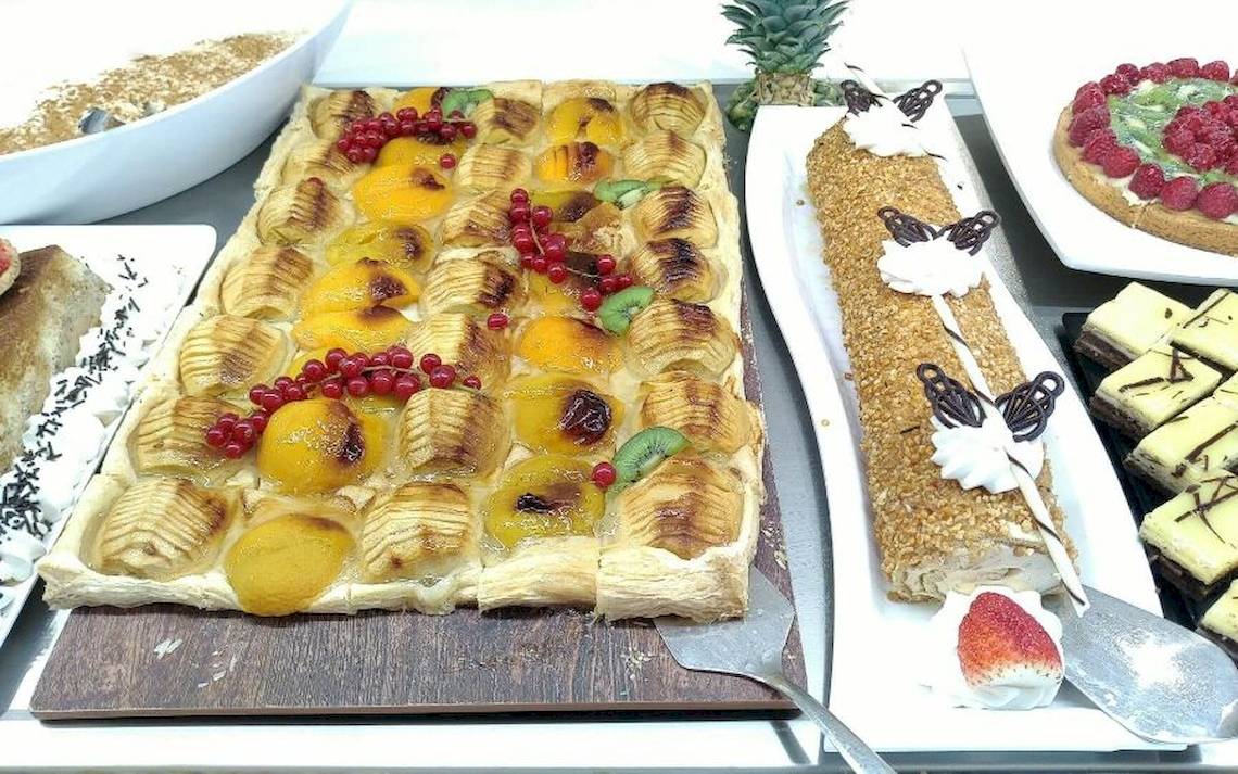 Buffet mit verschiedenen Obstgerichten und Desserts auf einem Tisch.