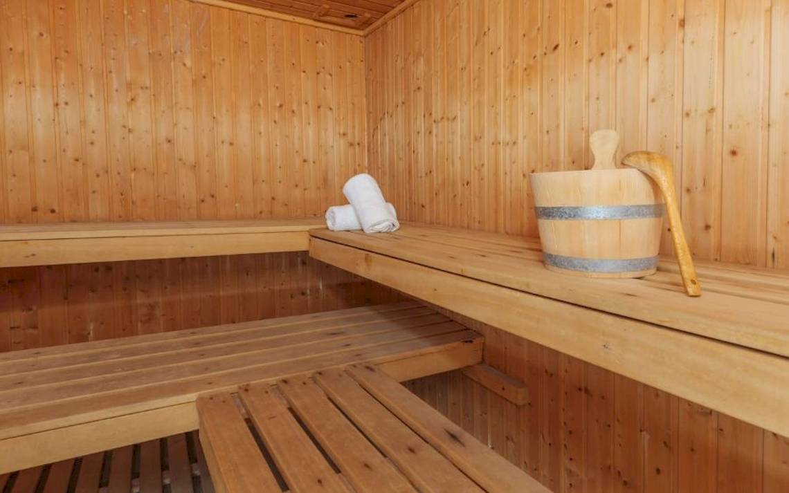 Innenansicht der Sauna im Aparthotel Fontanellas Playa mit Holzbänken und Handtuch