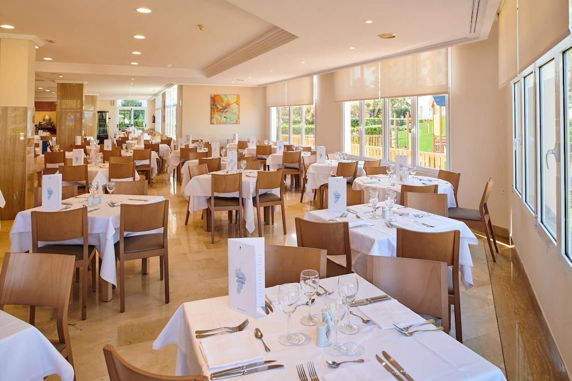 Innenansicht des Restaurants im Hipotels Flamenco mit gedeckten Tischen und Stühlen.
