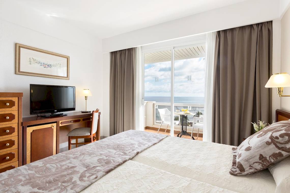 Zimmer im Hipotels Flamenco Hotel mit Blick auf das Meer und eine Terrasse.