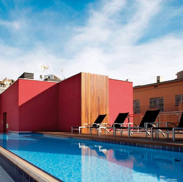 Pool auf der Dachterrasse des Barcelona Catedral Hotels mit roten Wänden und Lounge-Liegestühlen