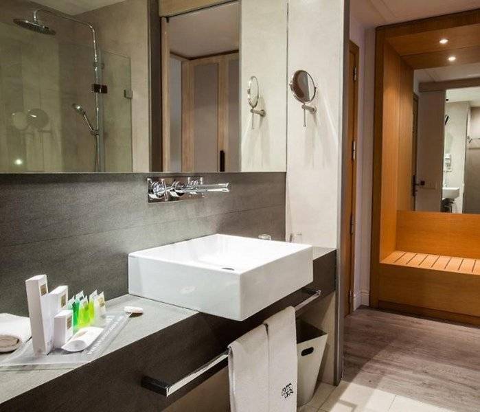 Badezimmer im Barcelona Catedral Hotel mit einer weißen Wanne, Handtüchern und Toilettenartikeln.