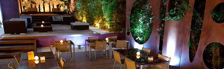 Terrasse des Barcelona Catedral Hotels mit Tischen, Stühlen und Pflanzenwänden