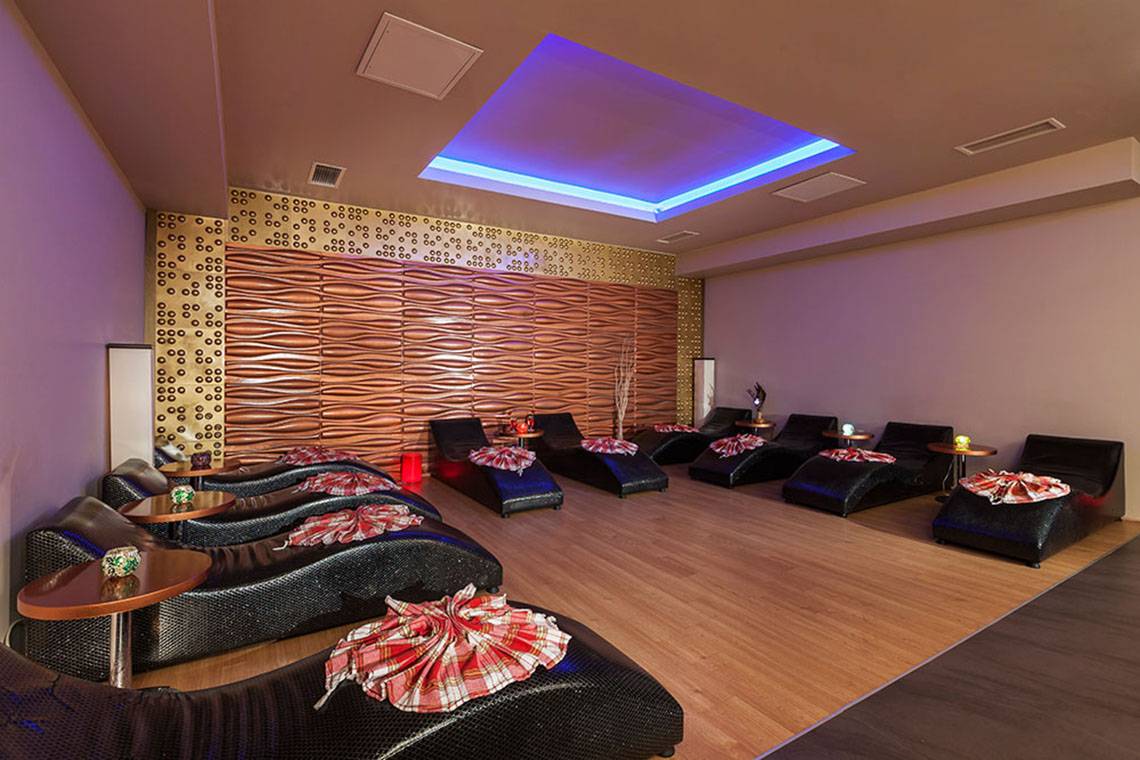 Lounge-Bereich im Hotel Sultan of Side mit schwarzen Liegen und braunen Holzböden.