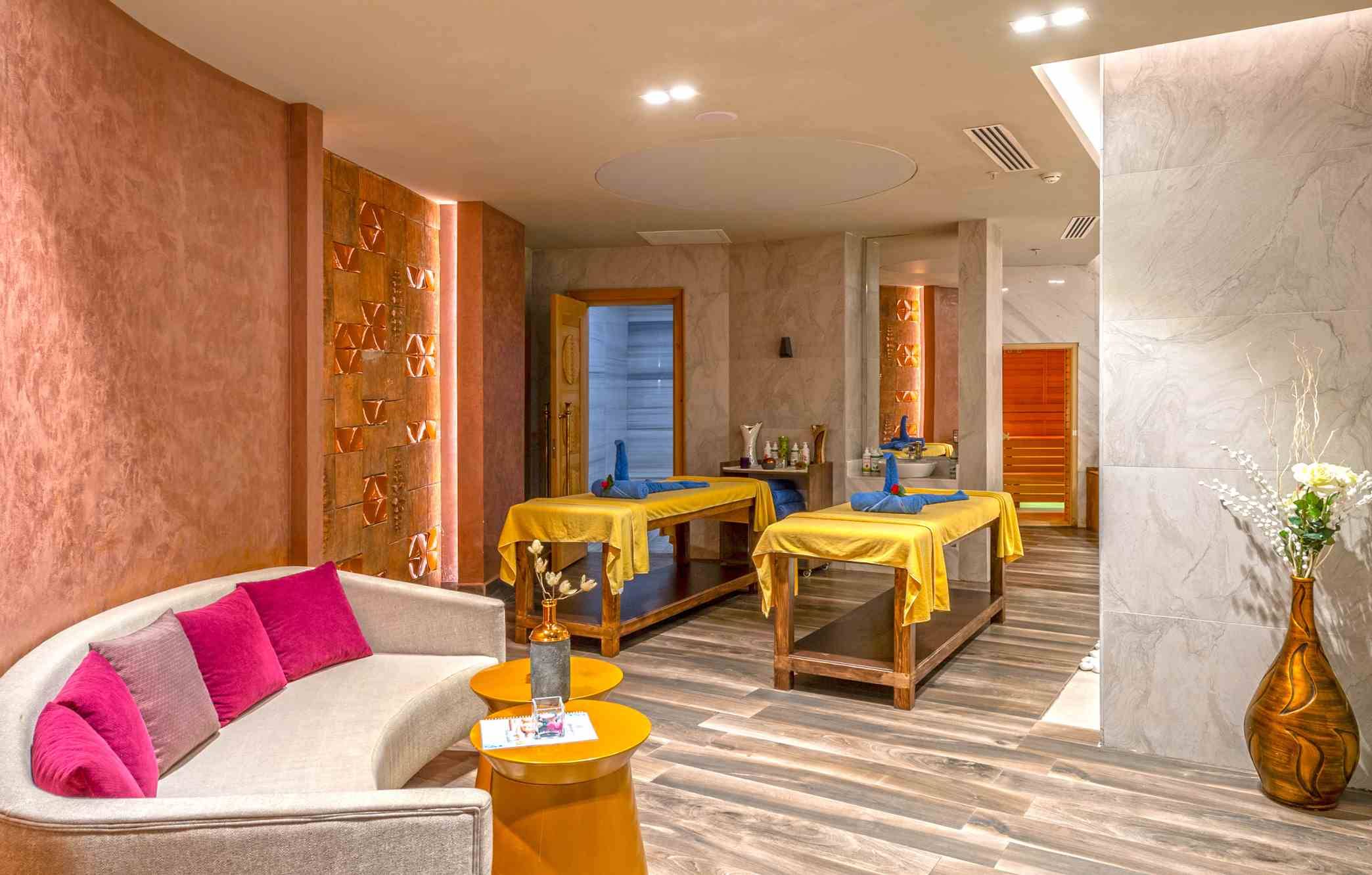 Spa-Behandlungsraum im Sidemarin Kirman Premium Hotel mit zwei Behandlungstischen und einem Sofa.