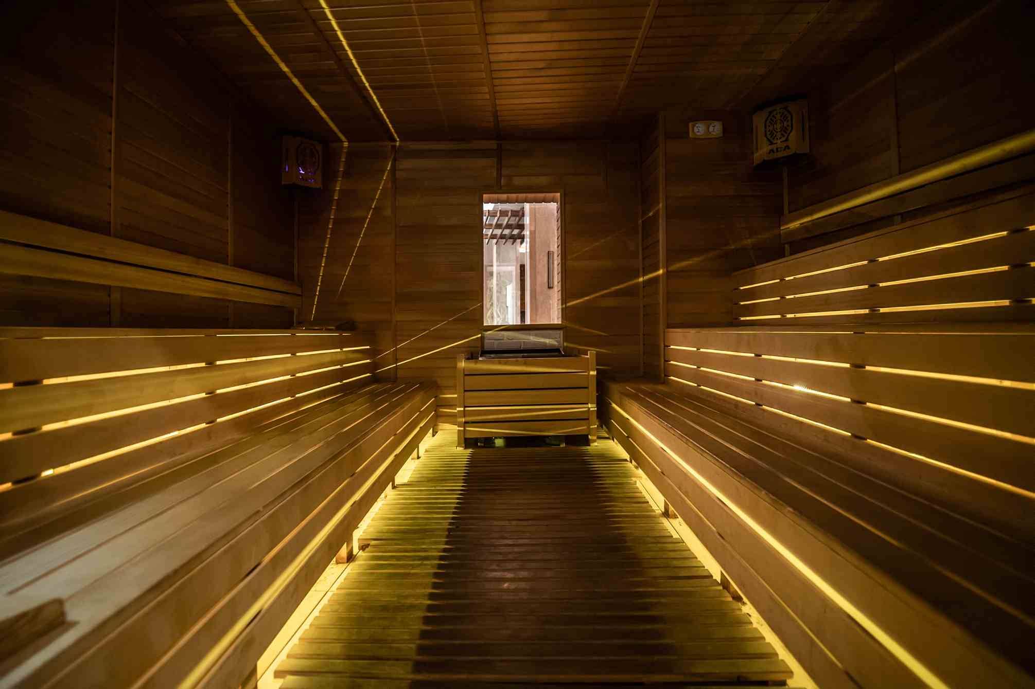 Innenansicht der Sauna im Sidemarin Kirman Premium mit Holzbänken und beleuchteten Wegen.