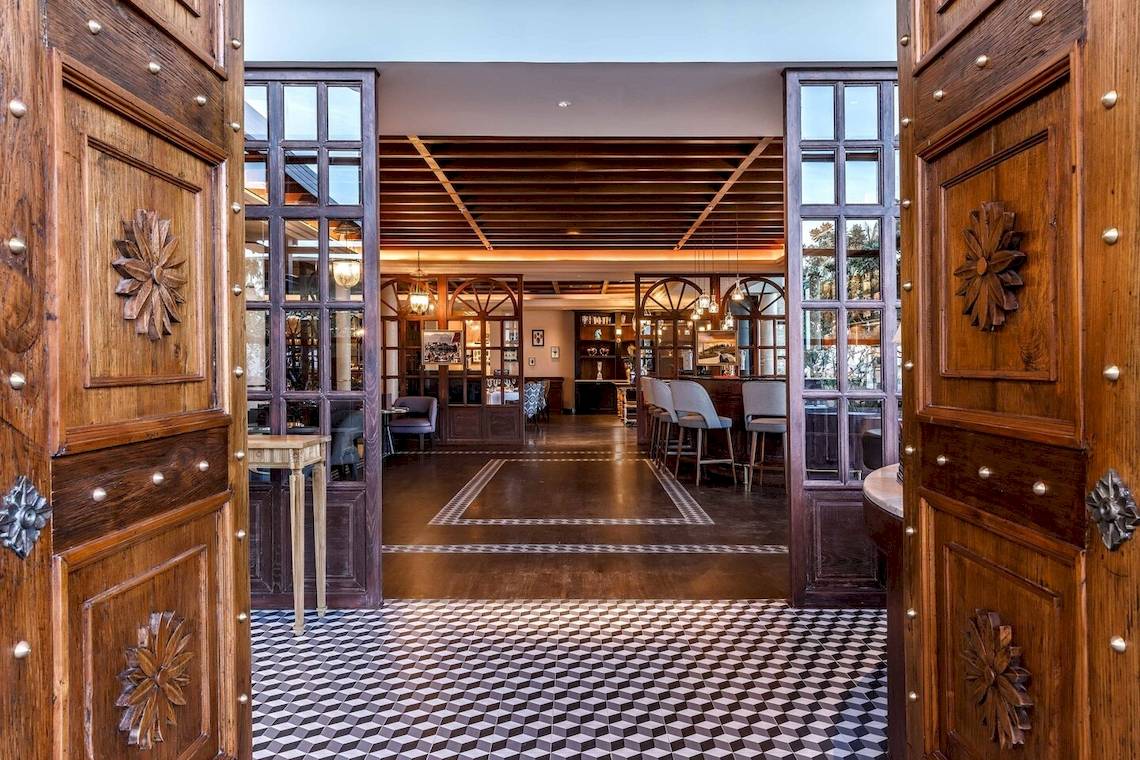 Eingangsbereich des JW Marriott Khao Lak Resort & Spa mit Holztüren und gefliestem Boden.