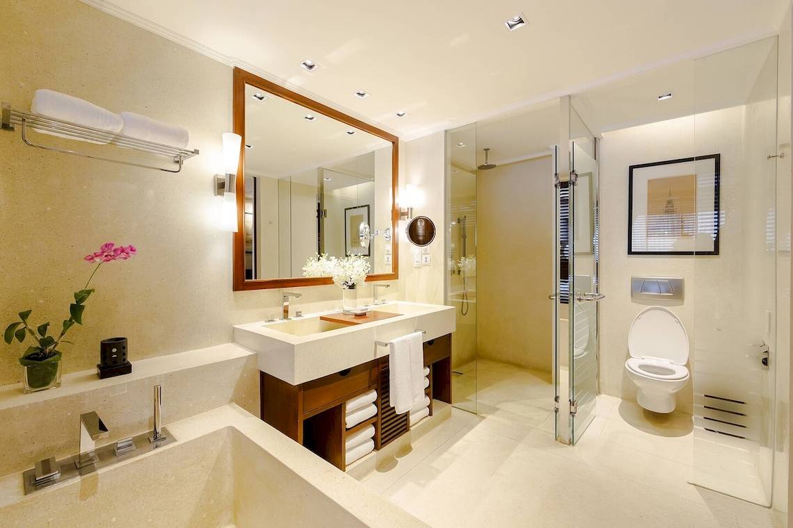 Badezimmer im JW Marriott Khao Lak Resort & Spa mit Doppelwaschbecken, Badewanne, Glasdusche und Toilette.