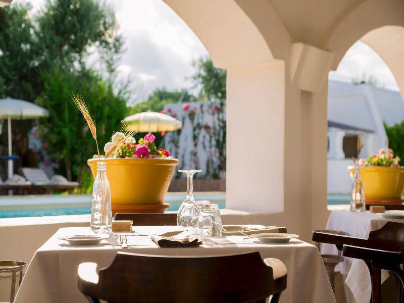 Ein Tisch auf der Terrasse des Hotels Il Melograno mit einem Blick auf den Pool.