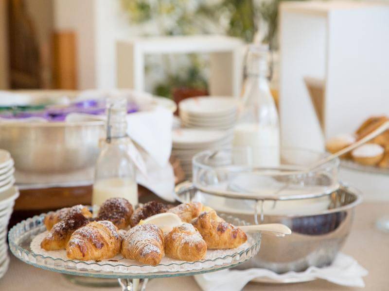 Frühstücksbuffet im Hotel Il Melograno mit Croissants, Milch und Kaffee