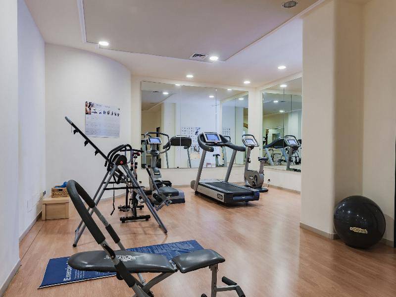 Fitnesscenter im Hotel Il Melograno mit verschiedenen Trainingsgeräten und einem großen Fitnessball.