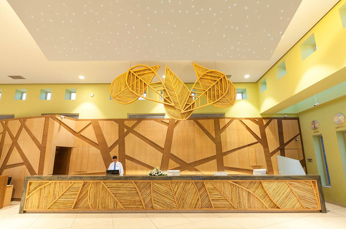 Empfangsbereich des Blue Lagoon Resorts mit Rezeption und dekorativem Blattdesign an der Decke.