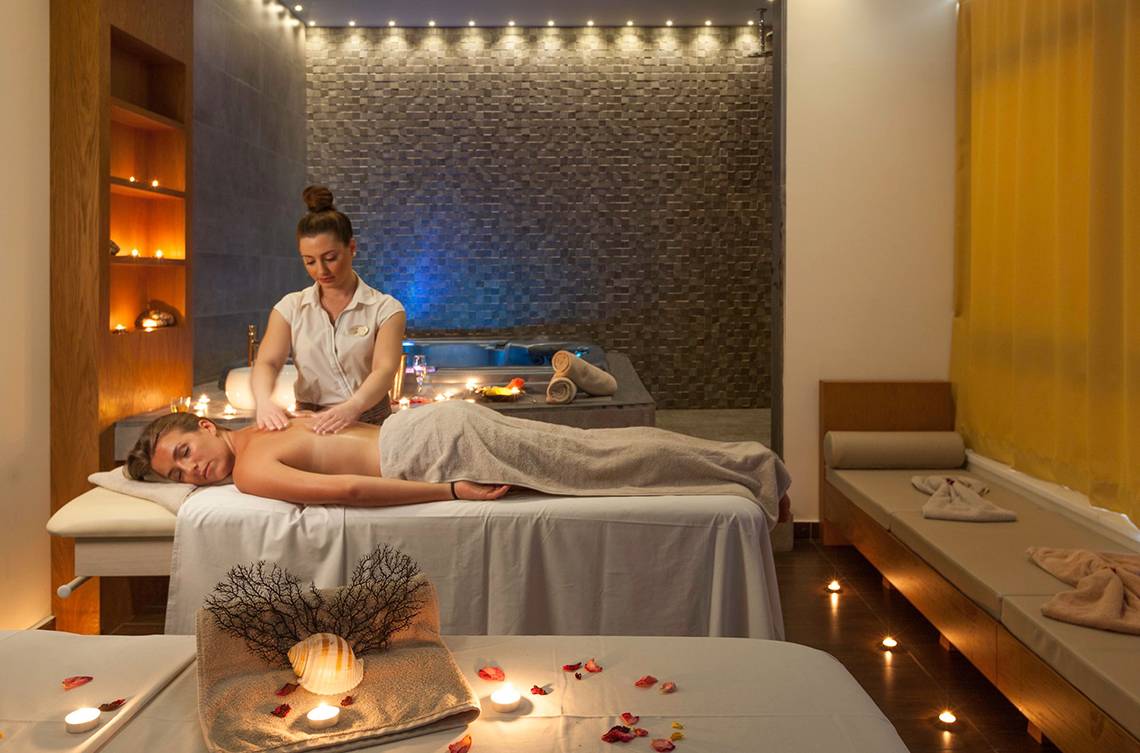 Spa-Massage im Blue Lagoon Resort mit Beleuchtung und Whirlpool im Hintergrund.