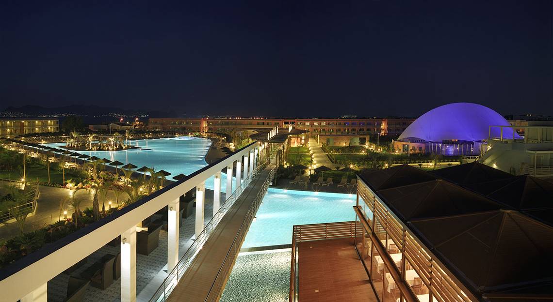 Luftaufnahme des Blue Lagoon Resorts bei Nacht mit Swimmingpool und blauer Kuppel