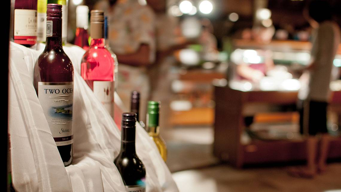 Weinflaschen im Laden des Fihalhohi Island Resorts, teilweise in Tüten verpackt, mit einem Blurred Hintergrund.