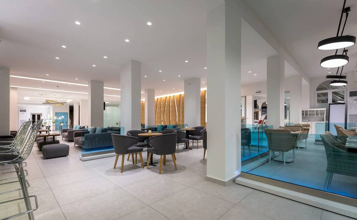 Innenansicht der Lobby des Acharavi Beach Hotel mit modernen Möbeln und hellem Design.