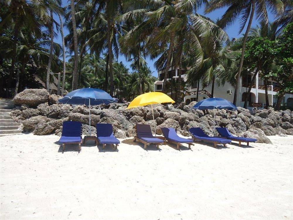 Strand der Severin Sea Lodge mit Liegen und Sonnenhüten vor einem Gebäude