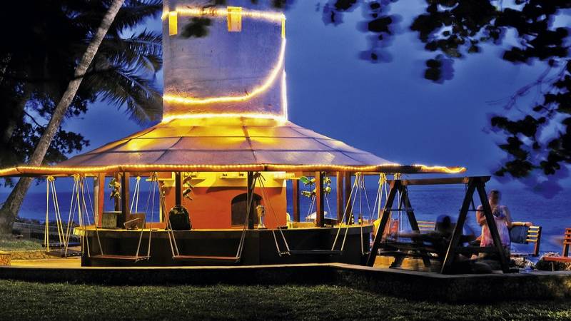 Severin Sea Lodge mit beleuchteter Bar und Sitzgelegenheiten im Freien bei Sonnenuntergang.