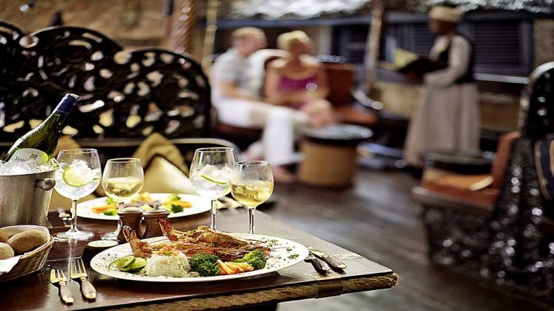 Essen auf dem Tisch in der Severin Sea Lodge mit Wein und verschiedenen Gerichten.