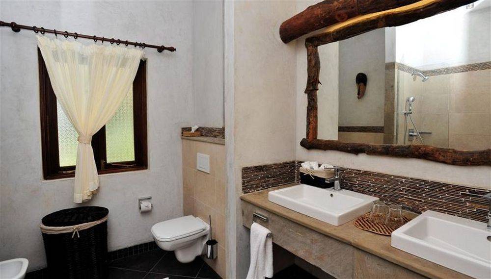 Badezimmer der Severin Sea Lodge mit zwei Waschbecken, Spiegel und Toilette.