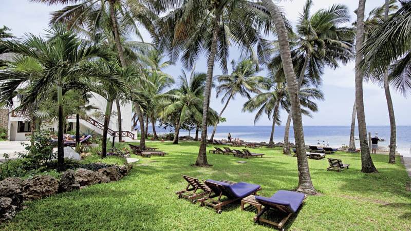 Außenbereich des Severin Sea Lodge Hotels mit Strand, Liegestühlen und Palmen