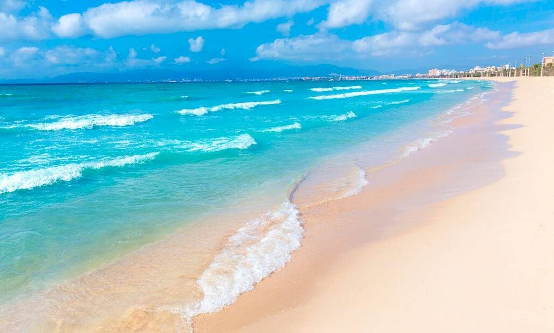 Strand des HM Gran Fiesta Hotels mit blauem Wasser und weißen Wellen