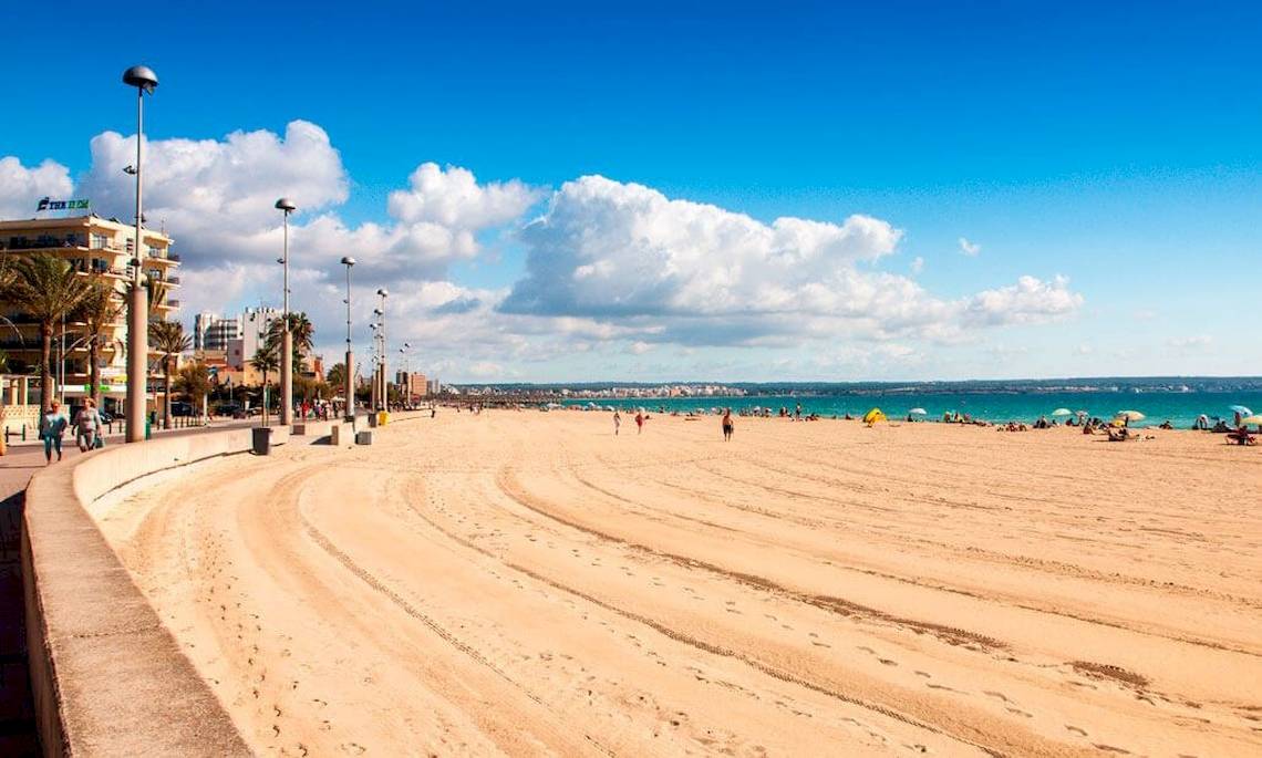 Strand am HM Gran Fiesta Hotel mit einigen Besuchern und Palmen.