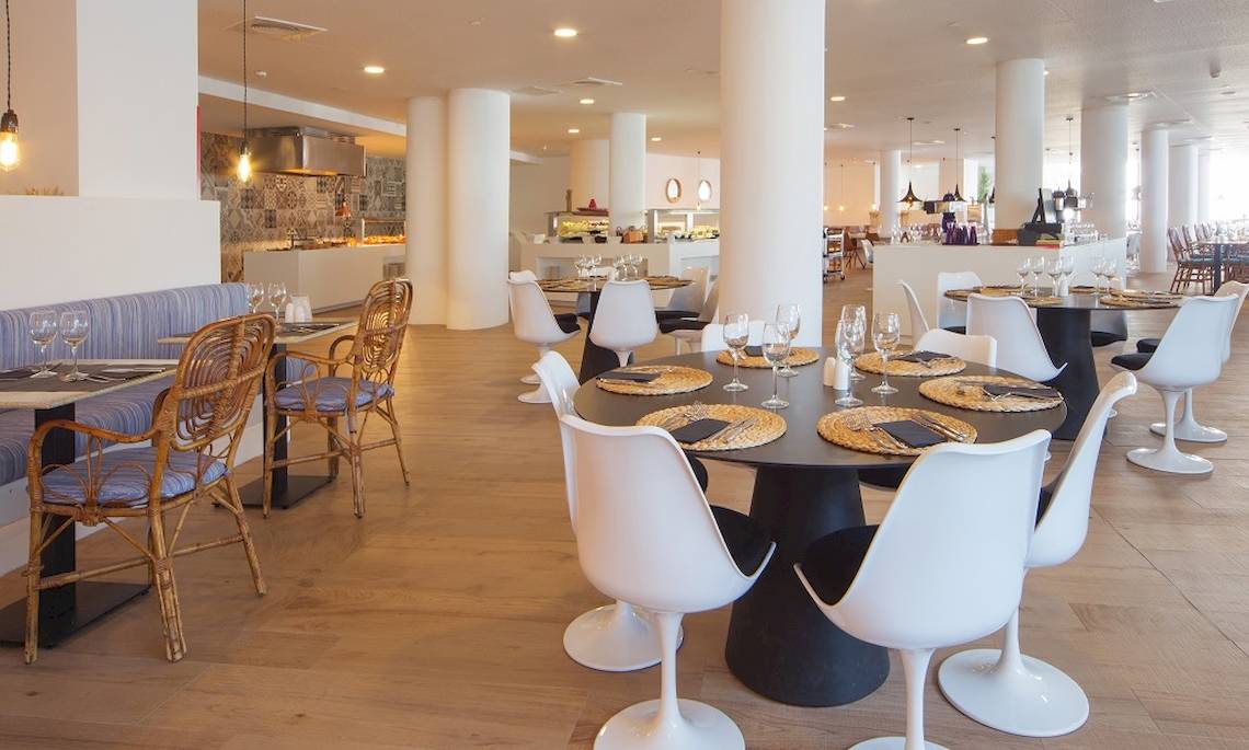 Innenansicht des Restaurants im HM Gran Fiesta Hotel mit modernen Möbeln und Holzboden.