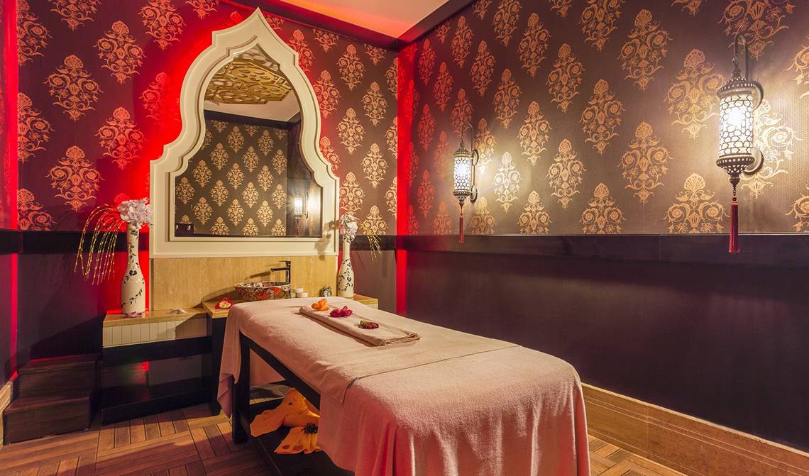 Spa-Behandlungsraum in der Villa Side Residence mit rotem Wanddesign und orientalischen Mustern.