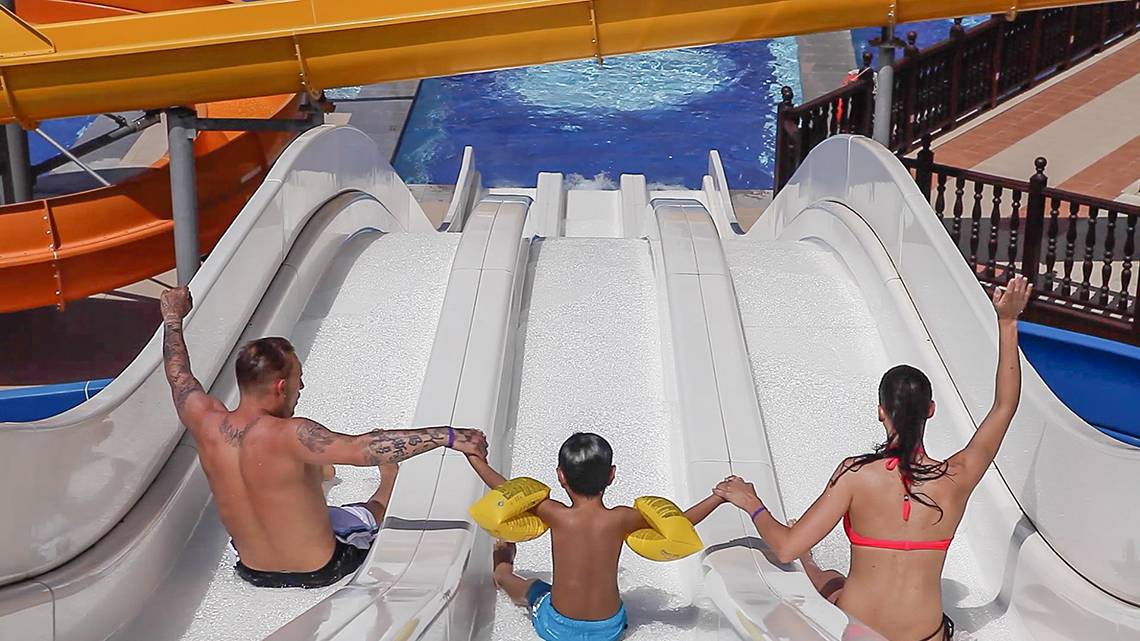 Familie auf der Wasserrutsche im Wasserpark der Villa Side Residence