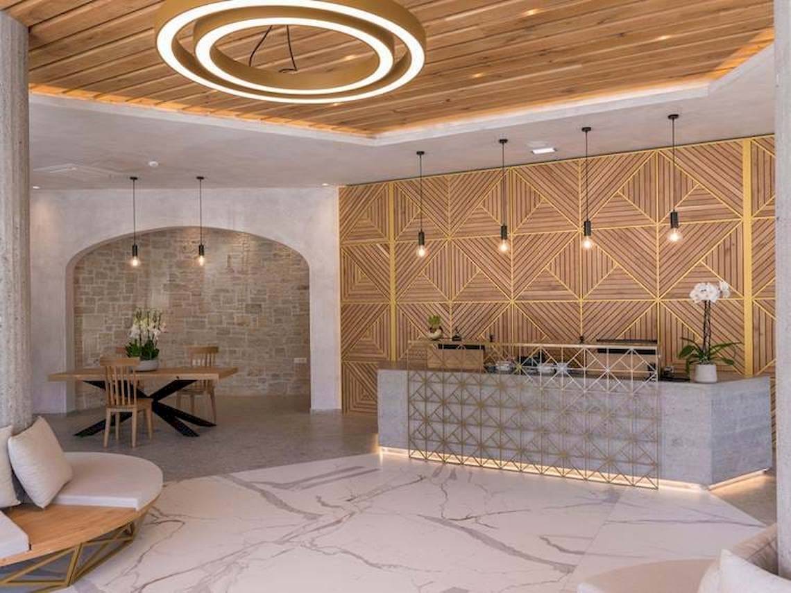 Innenansicht der Rezeption des Cactus Mare Hotels mit Marmorboden, Holzdecke und architektonischen Details.