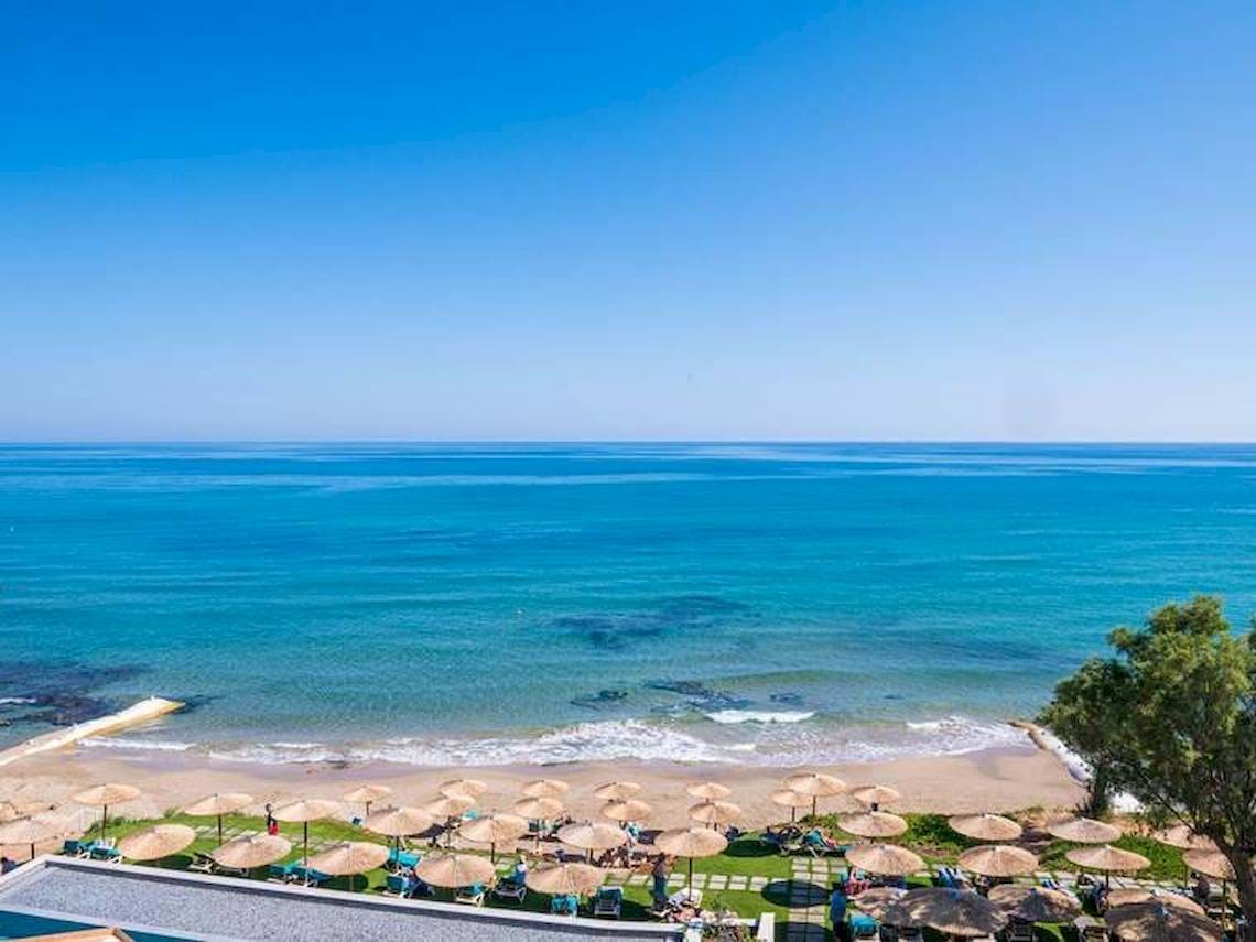 Aussicht auf den Strand mit Hotel Cactus Mare und vielen Sonnenschirmen.