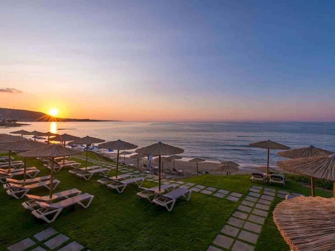 Sonnenuntergang am Strand des Cactus Mare Hotels mit vielen Sonnenliegen und Sonnenschirmen.