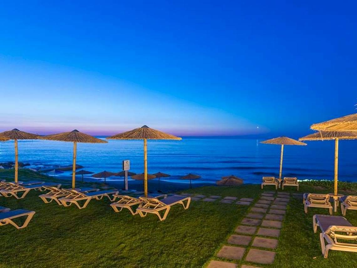 Strandszene mit Lounge-Sonnenliegen bei Sonnenuntergang im Cactus Mare Hotel.