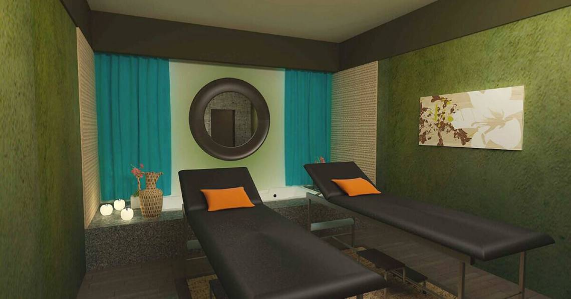 Massagesalon im Melia Marina Varadero mit zwei schwarzen Liegen, runden Spiegeln und grünen Wänden.