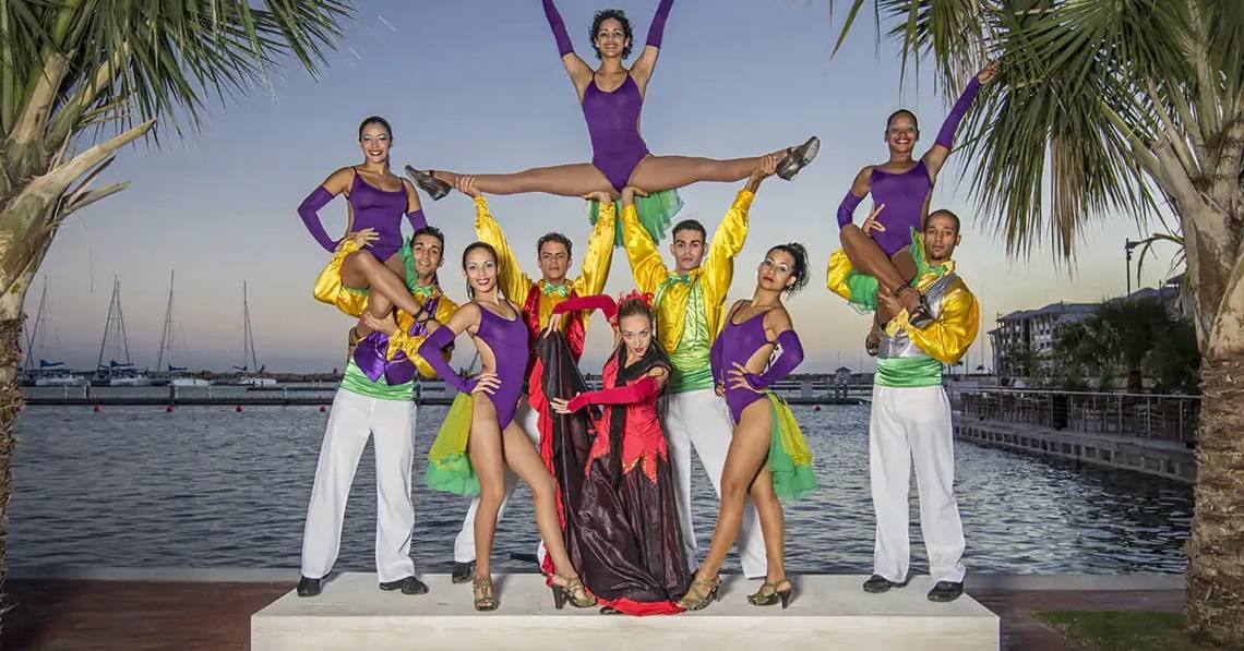 Gruppe von Akrobaten in bunten Kostümen vor dem Hafen des Melia Marina Varadero Hotels.