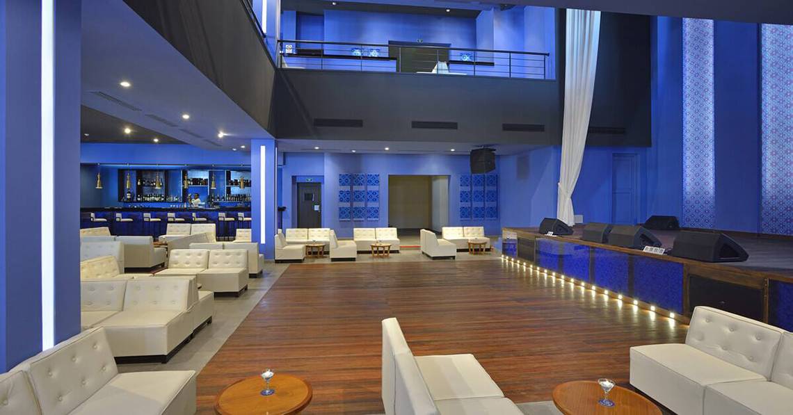 Lobby des Melia Marina Varadero Hotels mit weißen Sofas, blauen Wänden und einer Bar.