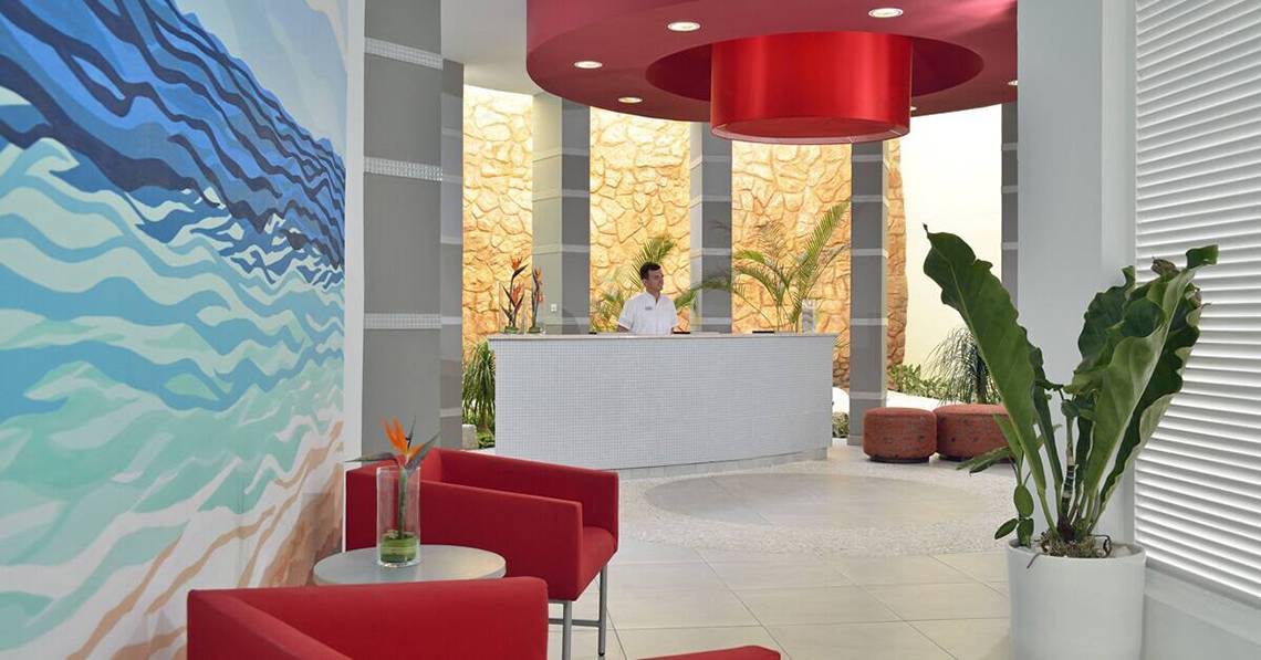 Empfangsbereich des Melia Marina Varadero Hotels mit roter Decke und Rezeptionstisch.