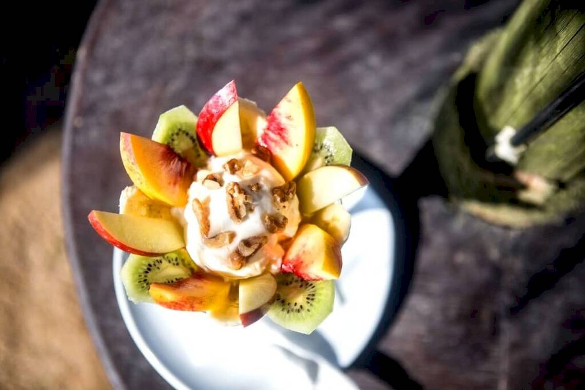 Obstsalat mit Sahne und Nüssen auf dem Tisch im Hotel Plaza Beach